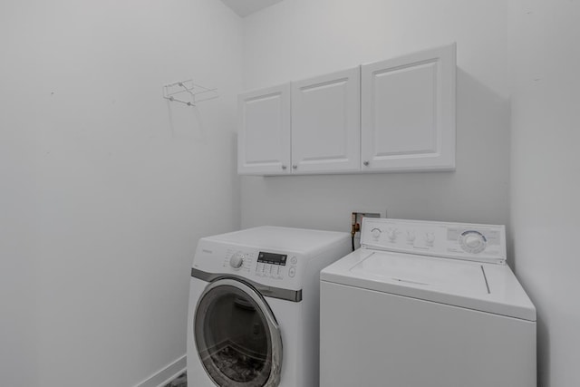 laundry area with washer and dryer and cabinets