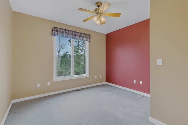 empty room featuring light colored carpet and ceiling fan