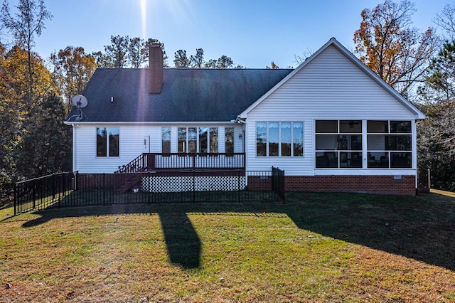 rear view of property with a wooden deck, a yard, and a sunroom