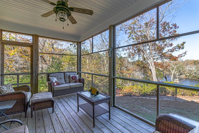 sunroom with a water view, ceiling fan, and a wealth of natural light