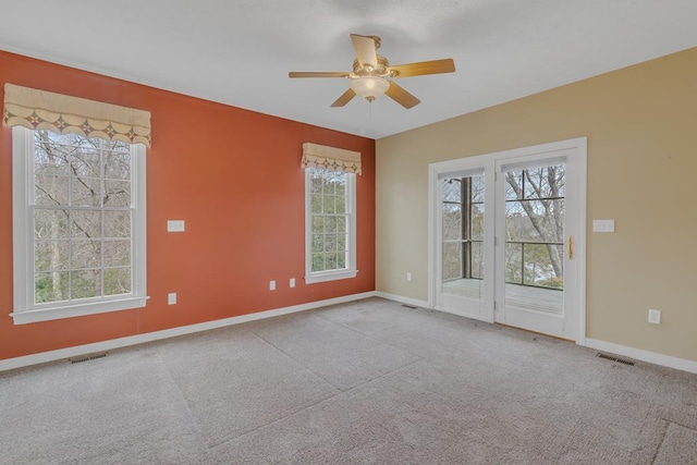 unfurnished room with light colored carpet and ceiling fan