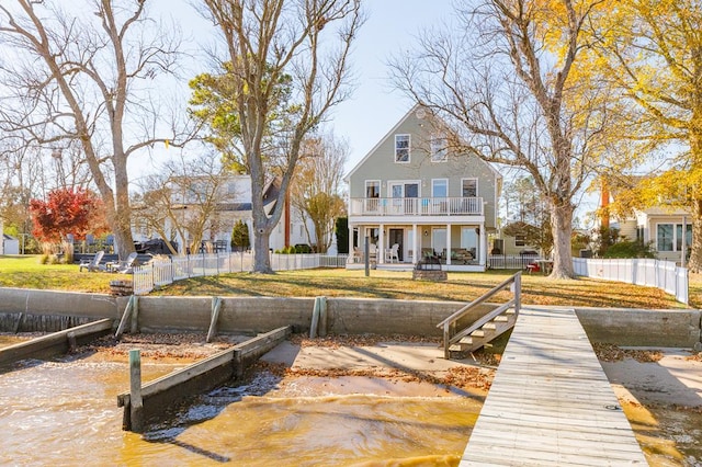 back of property with a balcony and a water view