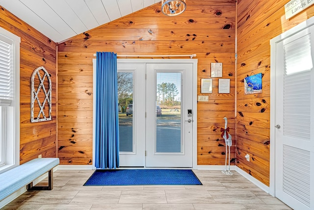 entrance foyer featuring wood walls and vaulted ceiling