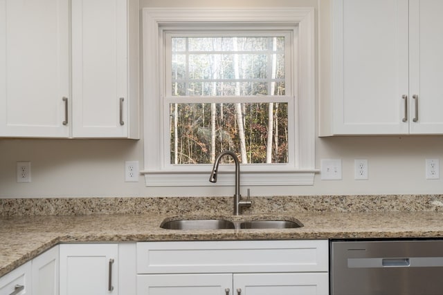 kitchen featuring sink, stainless steel dishwasher, white cabinets, and light stone counters