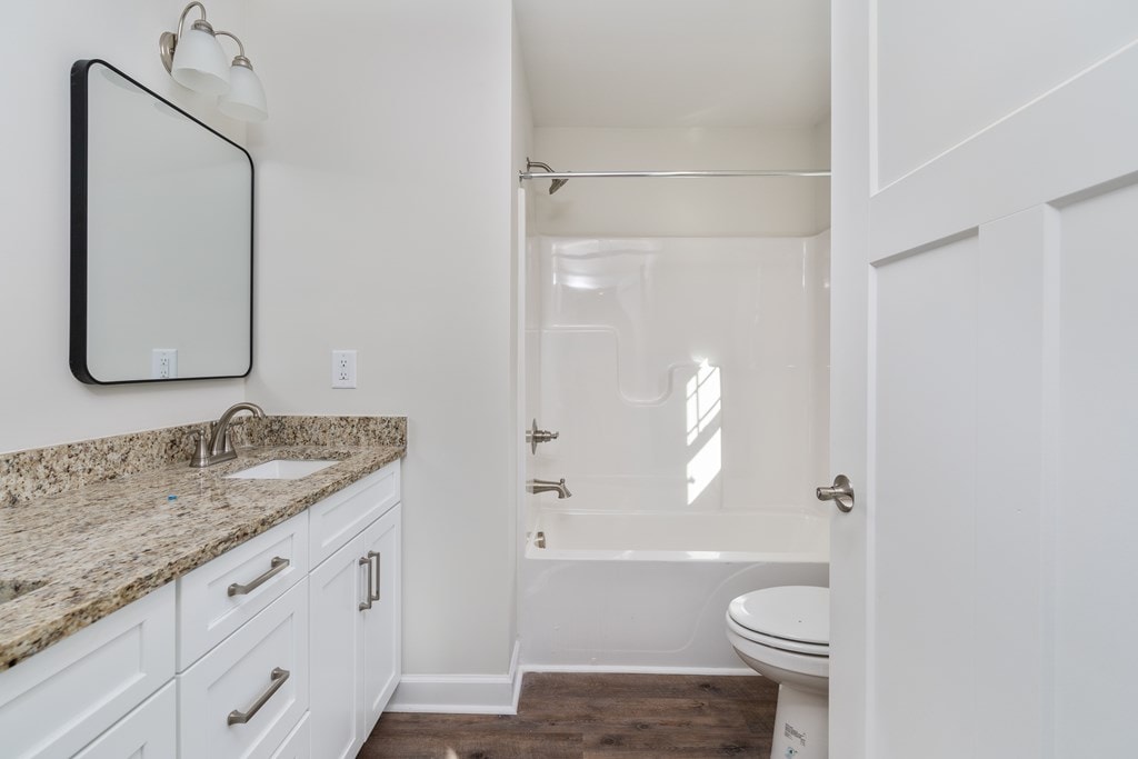 full bathroom with hardwood / wood-style flooring, vanity, toilet, and bathing tub / shower combination