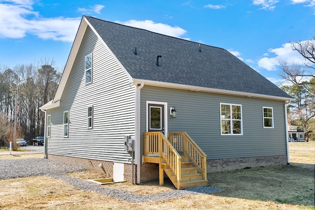 rear view of property featuring a shingled roof