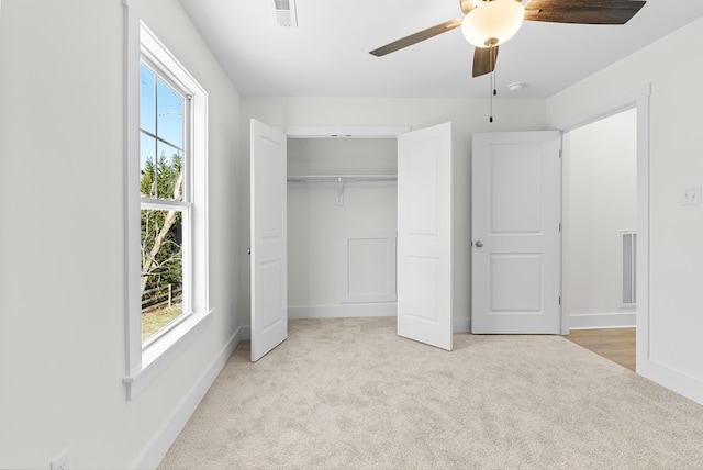 unfurnished bedroom featuring carpet floors, baseboards, multiple windows, and visible vents