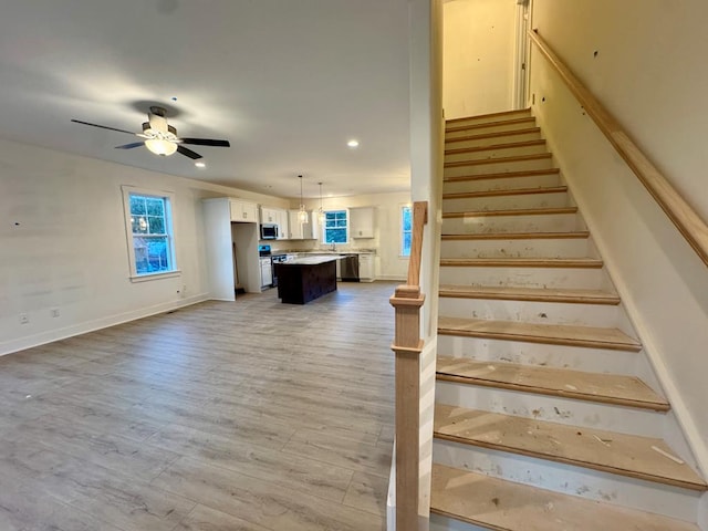 stairs with ceiling fan and wood-type flooring