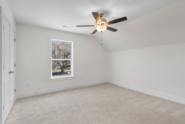 additional living space with light carpet, baseboards, visible vents, lofted ceiling, and ceiling fan