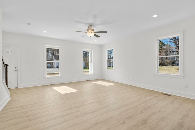 empty room with baseboards, light wood finished floors, visible vents, and recessed lighting