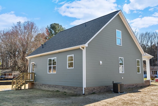 view of home's exterior featuring a shingled roof and cooling unit