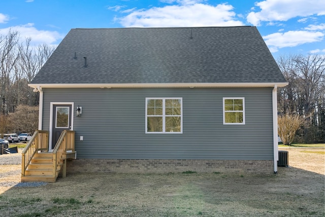 rear view of house with a shingled roof and central air condition unit