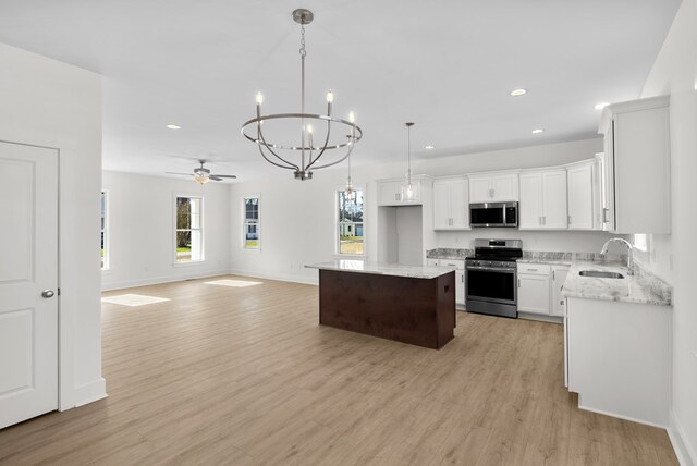 kitchen featuring white cabinets, sink, light stone countertops, and stainless steel appliances