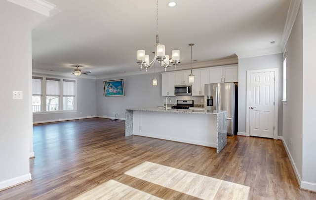 kitchen featuring white cabinetry, crown molding, stainless steel appliances, and a center island with sink