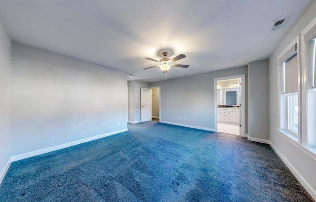 spare room with dark carpet and ceiling fan