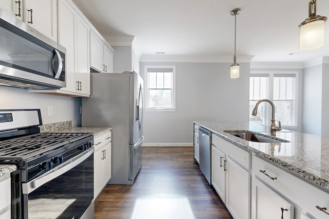 kitchen featuring pendant lighting, sink, white cabinetry, stainless steel appliances, and light stone counters