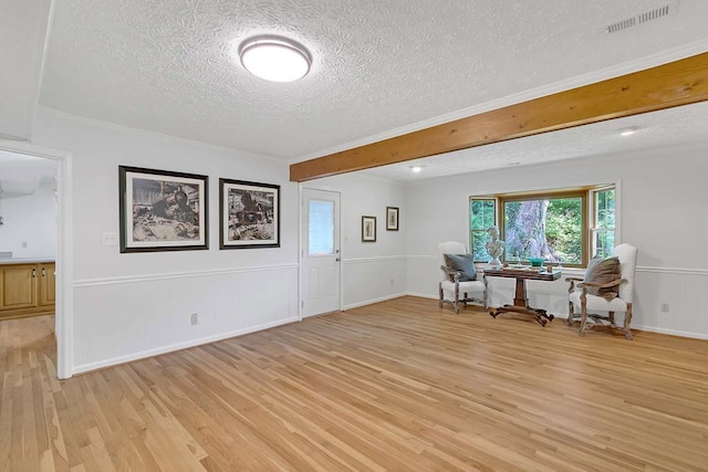 94 Arcadia Dr, Newport News, VA 23608 - living area with a textured ceiling, light wood-style floors, plenty of natural light, a wainscoted wall, and beamed ceiling