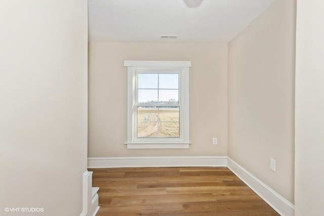 spare room with light wood-type flooring, baseboards, and visible vents