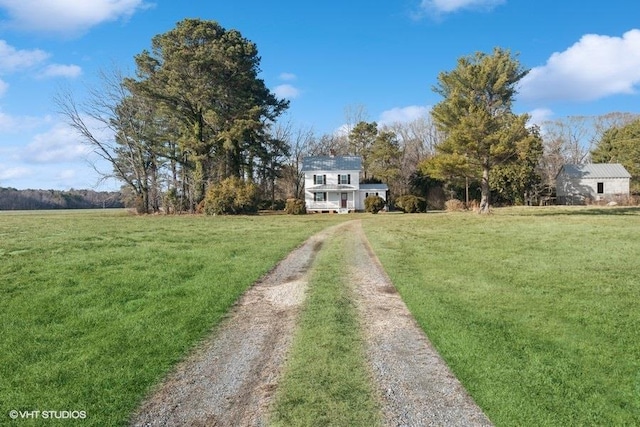 exterior space with driveway, a front lawn, and a rural view