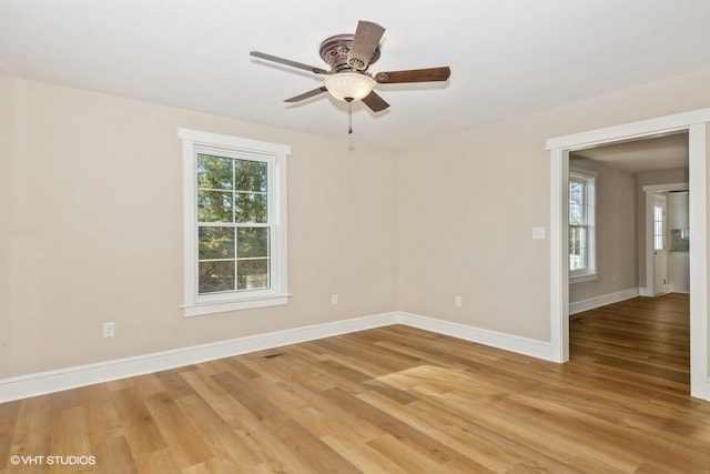 empty room with a ceiling fan, baseboards, and wood finished floors