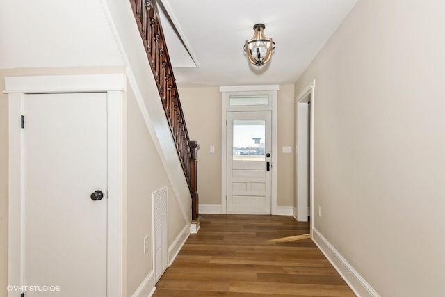 doorway featuring visible vents, stairway, baseboards, and wood finished floors