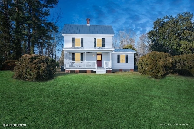 view of front of property with a chimney, metal roof, covered porch, a standing seam roof, and a front yard