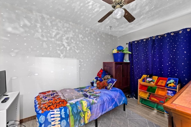 bedroom with wood-type flooring, a textured ceiling, and ceiling fan