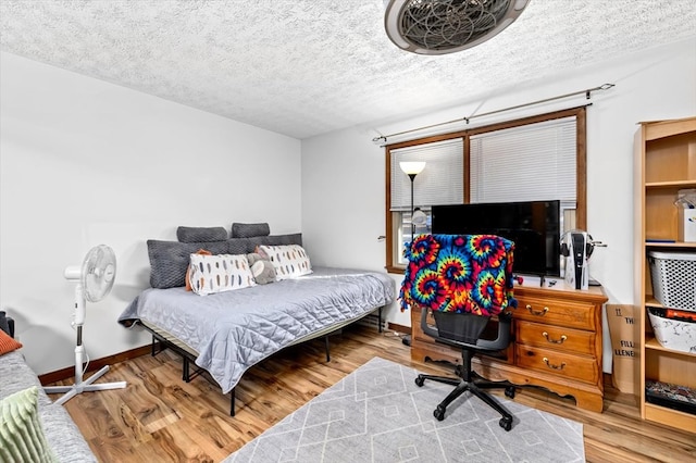 bedroom featuring hardwood / wood-style flooring and a textured ceiling