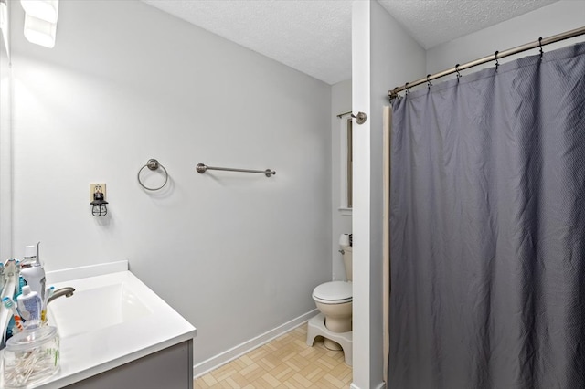 bathroom featuring vanity, parquet floors, toilet, and a textured ceiling