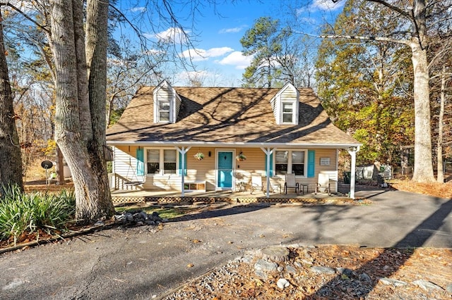 cape cod-style house featuring covered porch