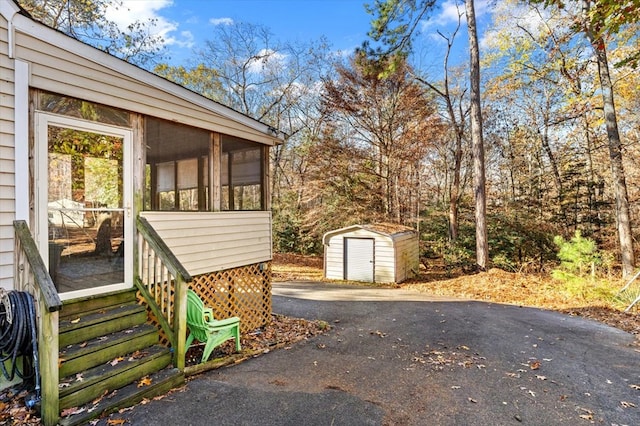 view of side of home featuring a shed and a sunroom