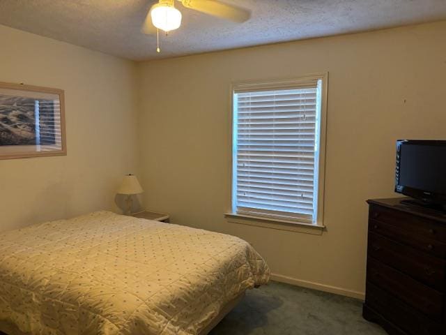 carpeted bedroom with ceiling fan, a textured ceiling, and baseboards