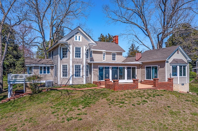 back of property with a lawn, a sunroom, and central AC unit