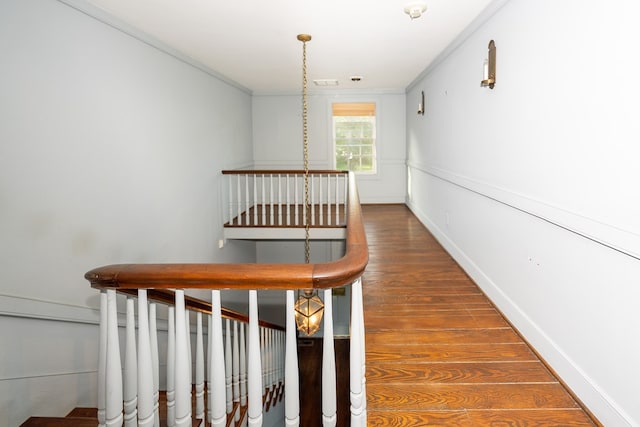 stairs featuring hardwood / wood-style flooring and ornamental molding