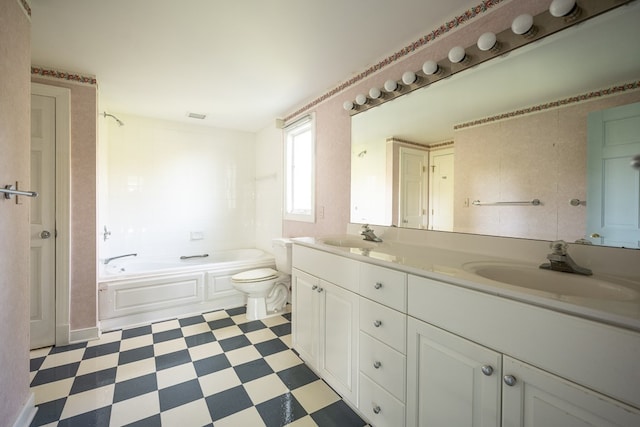 bathroom with vanity, toilet, and a tub