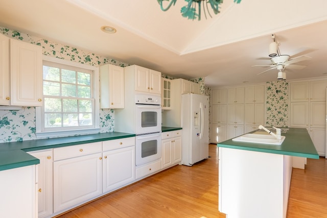 kitchen featuring a kitchen island with sink, white cabinets, light hardwood / wood-style floors, and white appliances