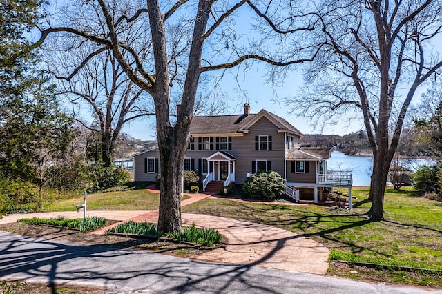 view of front of property with a water view and a front lawn