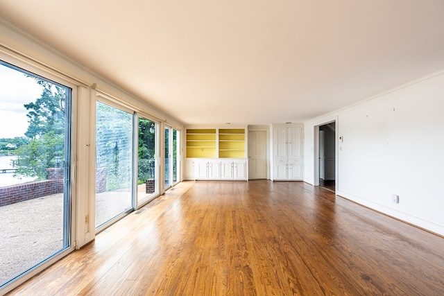 unfurnished living room with hardwood / wood-style flooring and built in features