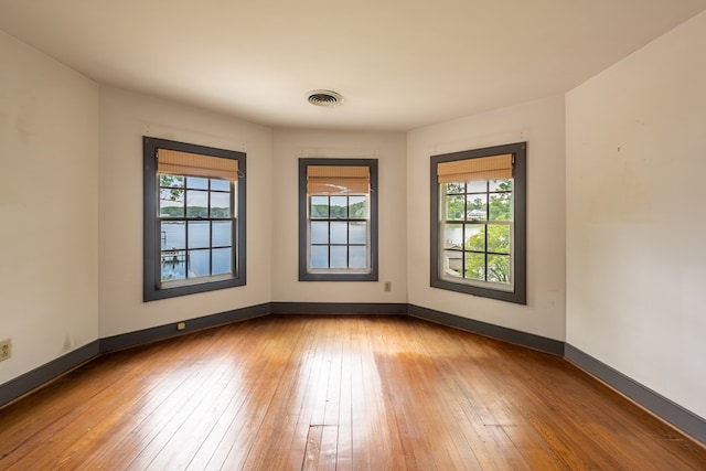 spare room with wood-type flooring and plenty of natural light