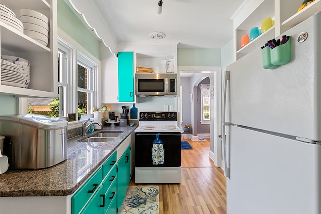 kitchen featuring sink, dark stone countertops, range with electric cooktop, white fridge, and light wood-type flooring