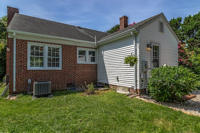 back of house featuring cooling unit and a lawn