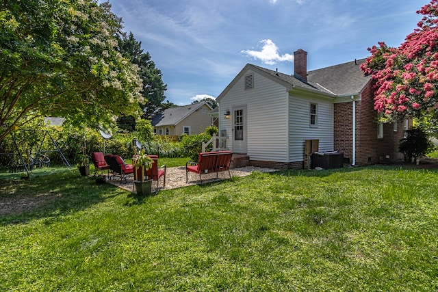 back of property with a lawn and a patio