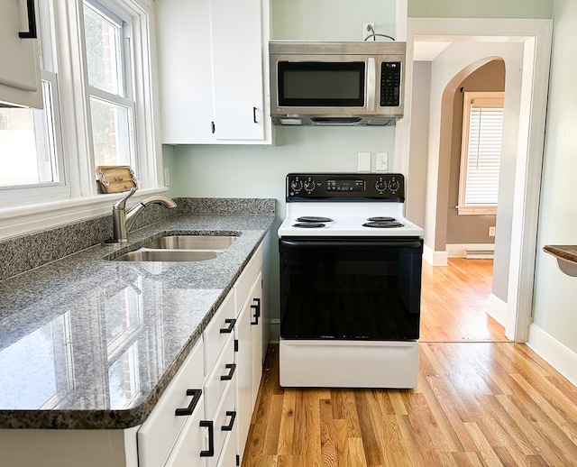 kitchen featuring white cabinetry, sink, electric range oven, and a wealth of natural light