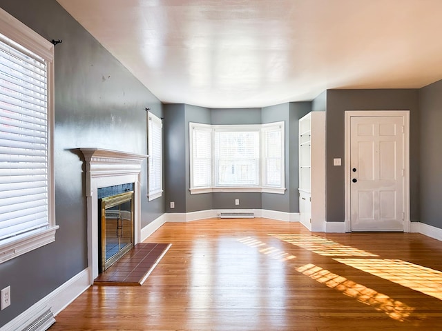 unfurnished living room featuring a fireplace and light hardwood / wood-style floors