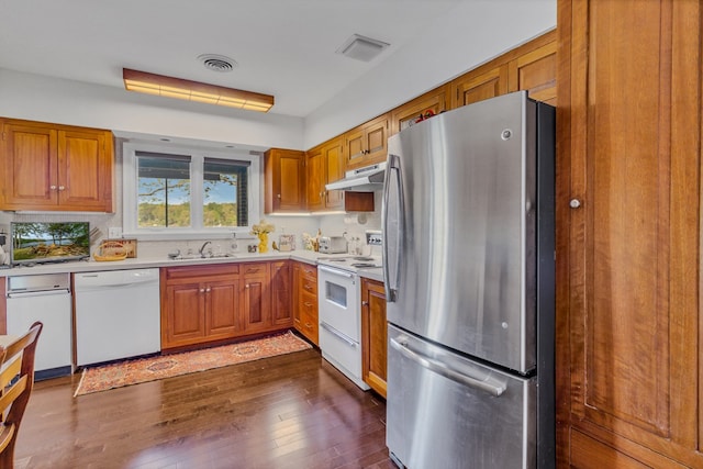 555 Rio Vis, Weems, VA 22576 - kitchen featuring white appliances, under cabinet range hood, light countertops, a sink, and dark wood-type flooring