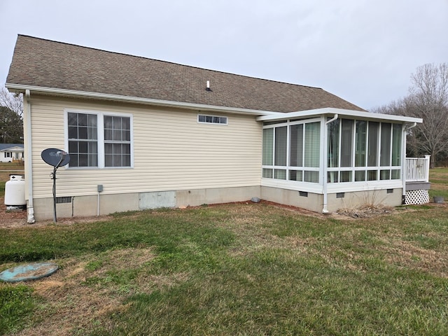 back of house featuring a lawn and a sunroom