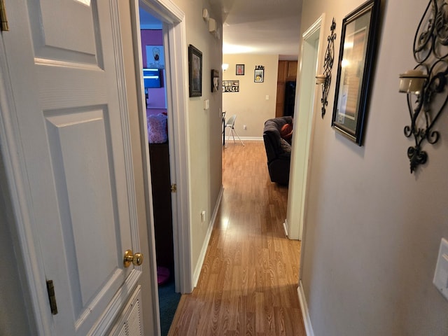 hallway with hardwood / wood-style flooring