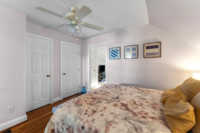 bedroom with ceiling fan, dark hardwood / wood-style flooring, and vaulted ceiling