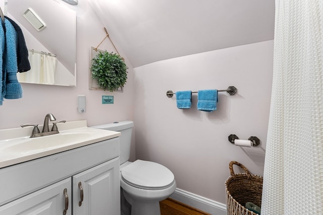 bathroom with toilet, hardwood / wood-style floors, vanity, and vaulted ceiling