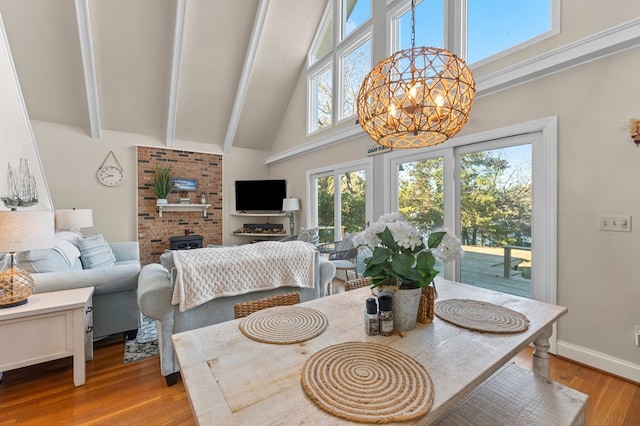 dining room with a chandelier, light wood-type flooring, and high vaulted ceiling